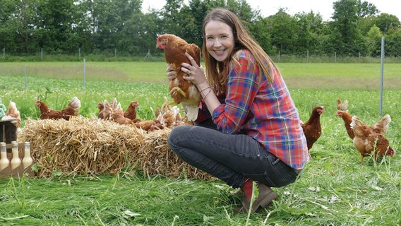 Agrarökonomin Lena Goldnick mit einer Henne. Ihr Betrieb produziert die ersten klimaneutralen Euer Deutschlands. © Hornbrooker Hof Foto: Hornbrooker Hof