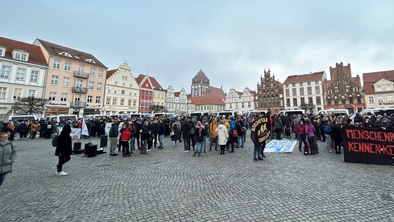 Protestierende einer Gegendemonstration stehen auf dem Platz einer Demonstration gegen die Unterbringung von Geflüchteten in Greifswald. © picture alliance Foto: Sven Käuler