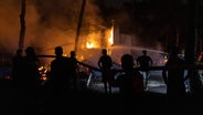 Griechenland, Mandra: Menschen versuchen, einen Flächenbrand zu löschen, der ein Haus niedergebrannt hat. ©  Lefteris Partsalis/XinHua/dpa 