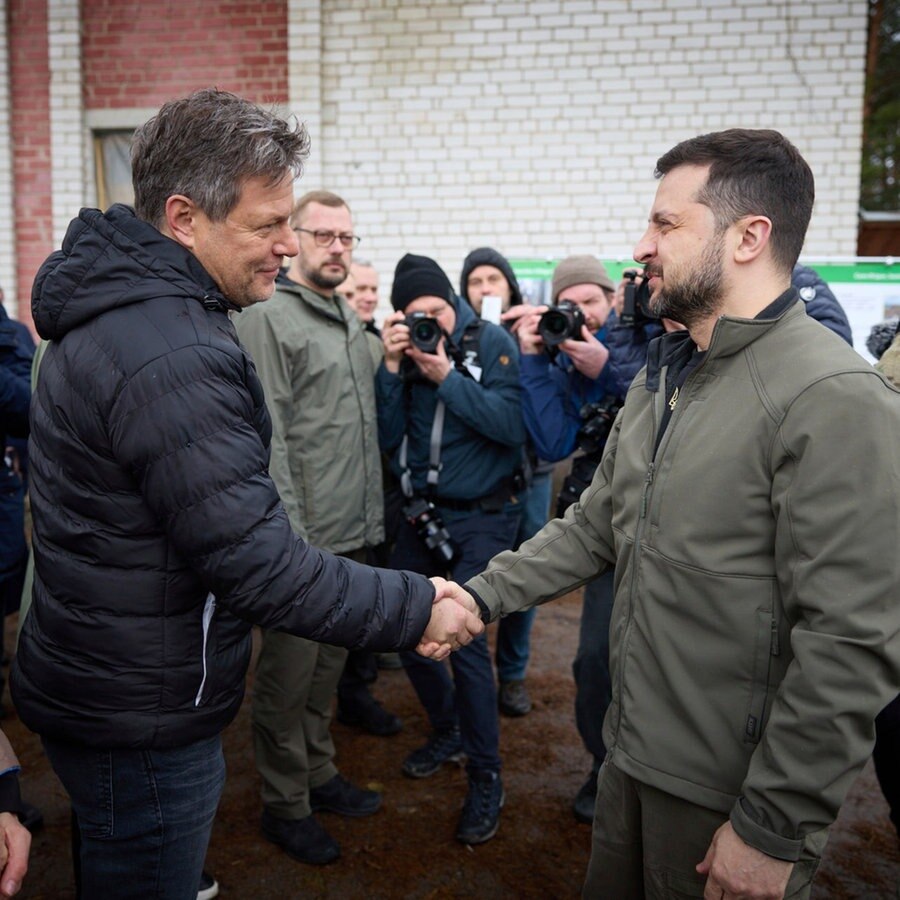 Wolodymyr Selenskyj (r), Präsident der Ukraine Zelenskyy, und Robert Habeck (Bündnis 90/Die Grünen), Bundesminister für Wirtschaft und Klimaschutz, geben sich die Hand bei einem Besuch in Jahidne. © picture alliance/dpa/Ukrainian Presidential Press Office/AP 