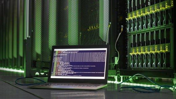 Ein aufgeklappter Laptop steht vor einem Serverschrank. © Imago Foto: Science Photo Library