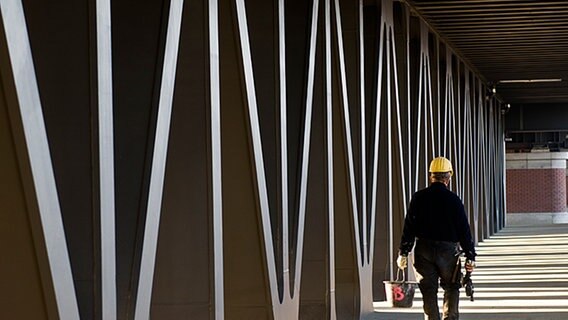 Ein Arbeiter geht über eine Brücke im Hamburger Hafen © dpa Foto: Jens Schierenbeck
