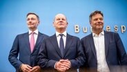 ARCHIV - 05.07.2024, Berlin: Bundeskanzler Olaf Scholz (SPD,M) Robert Habeck (Bündnis 90/Die Grünen , r), Bundesminister für Wirtschaft und Klimaschutz, und Christian Lindner (FDP), Bundesminister der Finanzen, nehmen an einer Pressekonferenz zum Haushaltsplan 2025 teil. Die Koalitionsparteien haben sich auf einen Entwurf zum Haushalt geeinigt. © dpa Foto: Michael Kappeler