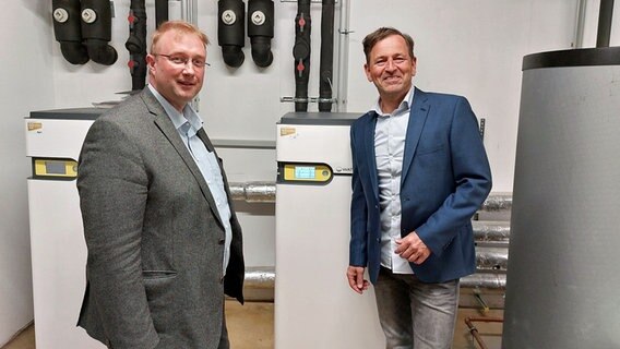 Thorsten Bock (links) und Axel Sörensen stehen in einem Heizungskeller und schauen in die Kamera. Thorsten Bock (links) und Axel Sörensen stehen in einem Heizungskeller und schauen in die Kamera. © NDR Foto: Arne Schulz