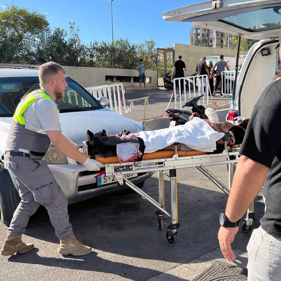 17.09.2024, Libanon, Beirut: Ersthelfer des Zivilschutzes bringen einen verletzten Mann, dessen tragbarer Pager explodiert ist, ins al-Zahraa-Krankenhaus. Bei einem mutmaßlich koordinierten Angriff im Libanon sind Hunderte Menschen verletzt worden - durch explodierende Telekommunikationsgeräte. © AP Foto: Hussein Malla