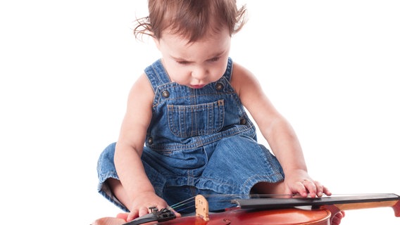 Ein Baby spielt mit einer Violine © Colourbox Foto: #1104