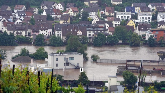 In Benningen am Neckar im Landkreis Ludwigsburg stehen Gebäude im Wasser des Neckars, der über die Ufer getreten ist. © Andreas Rosar/dpa Foto: Jason Tschepljakow