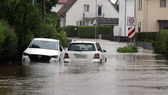 Autos stehen im Hochwasser der Mindel in einem Wohngebiet in Offingen in Bayern. © Karl-Josef Hildenbrand/dpa Foto: Karl-Josef Hildenbrand/dpa