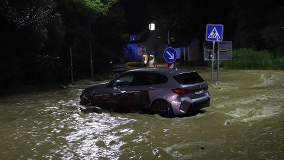 Baden-Württemberg, Ebersbach an der Fils: Ein Auto steht auf einer überfluteten Straße © Christian Wiediger/dpa Foto: Christian Wiediger