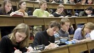Studenten aus dem ersten Semester sitzen im Hörsaal und machen sich Notizen. © dpa - Bildfunk Foto: Waltraud Grubitzsch