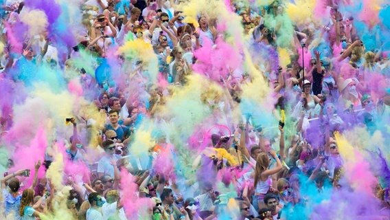 Tausende Besucher des "Holi Festival of Colors" bewerfen sich am 08.08.2015 in Hamburg mit buntem Farbpulver. © dpa Foto: Daniel Reinhardt