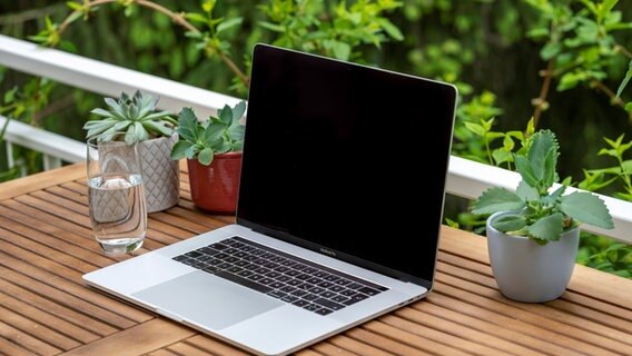 Homeoffice mit Laptop, Apple MacBook Pro und iPhone X am Schreibtisch, mit schwarzem Bildschirm. © picture alliance Foto: Mara Brandl