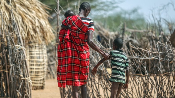 Kenia, Lomoputh: Ein Vater hilft seinem unterernährten Sohn beim Gehen in der Nähe ihrer Hütte in dem Dorf. © AP/dpa Foto: Brian Inganga