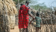 Kenia, Lomoputh: Ein Vater hilft seinem unterernährten Sohn beim Gehen in der Nähe ihrer Hütte in dem Dorf. © AP/dpa Foto: Brian Inganga