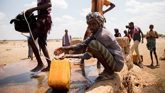 Ein äthiopischer Mann zapft an einem improvisierten Brunnen Wasser. © DPA Foto: Kay Nietfeld