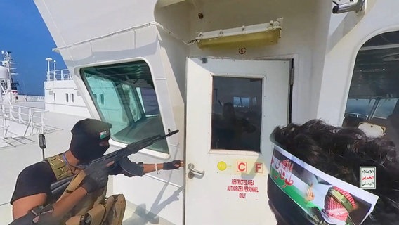Ein bewaffneter Huthi-Rebelle auf dem Deck eines Frachters im Roten Meer © Houthi Military Media Center/dpa 
