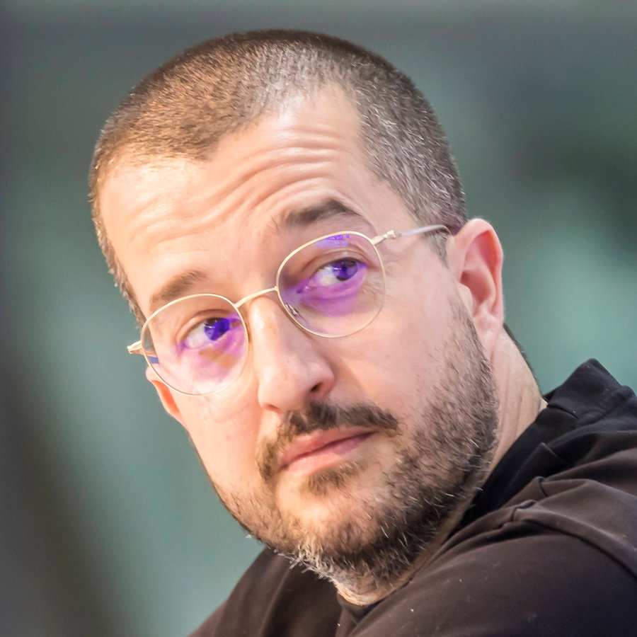Immobilien-Influencer Tommy Primorac blickt skeptisch nach links © IMAGO Foto: Arnulf Hettrich