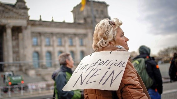 Demonstranten protestieren am Morgen vor dem Reichstagsgebäude mit Plakaten gegen eine Impfpflicht. © dpa Bildfunk Foto: Kay Nietfeld