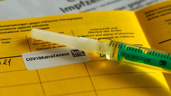 Eine Spritze liegt auf einem Impfpass. © Picture Alliance Foto: Matthias Stolt