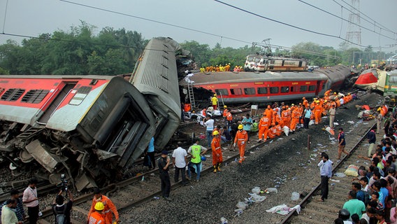 Rettungskräfte arbeiten an einer Unglücksstelle im indischen Balasore, wo drei Züge entgleisten. © dpa-Bildfunk/AP 