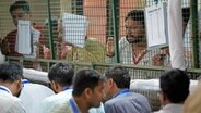 Wahlhelfer der politischen Parteien beobachten die Auszählung der Stimmen in einem Auszählungszentrum in Neu-Delhi. © Manish Swarup/AP/dpa Foto: Manish Swarup