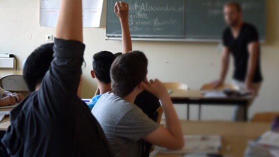 Eine Gruppe junger Flüchtlinge sitzt in einem Klassenzimmer und wird auf deutsch unterrichtet. © (c) dpa Foto: Britta Pedersen