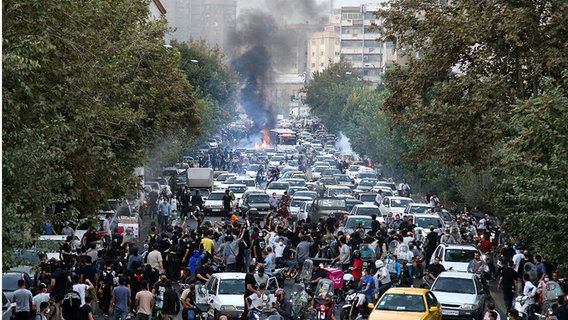 Menschen demonstrieren auf den Straßen Teherans. © picture alliance / AA | Stringer 
