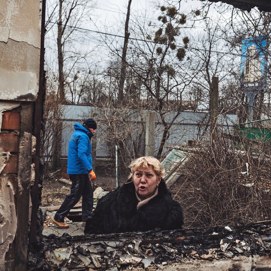 Eine Frau steht vor ihrem durch Bomben zerstörten Haus in Irpin, Ukraine. © dpa-Bildfunk 