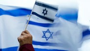 Eine Person hält eine Israel-Flagge auf einer Demonstration. © dpa-Bildfunk/AP Foto: Lindsey Wasson