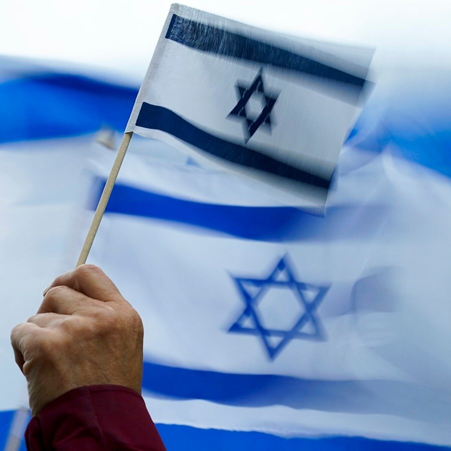 Eine Person hält eine Israel-Flagge auf einer Demonstration. © dpa-Bildfunk/AP Foto: Lindsey Wasson