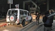 Ein Fahrzeug des Roten Kreuzes fährt im Dunklen im Gazastreifen auf einer Straße Richtung Grenzübergang nach Ägypten. © dpa-Bildfunk/AP Foto: Fatima Shbair