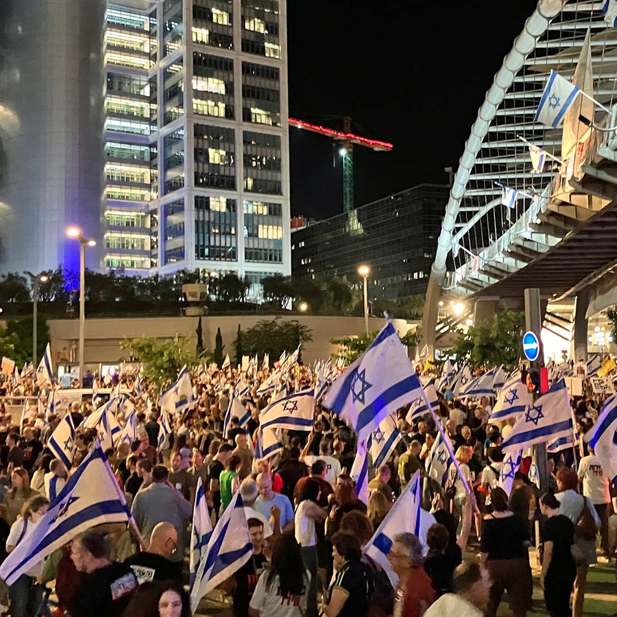 Menschen demonstrieren im Zentrum von Tel Aviv in der Derech Menachem Begin Street. Der Protest richtet sich gegen die israelische Regierung und für einen Geisel-Abkommen mit der Hamas. © Cindy Riechau/dpa 