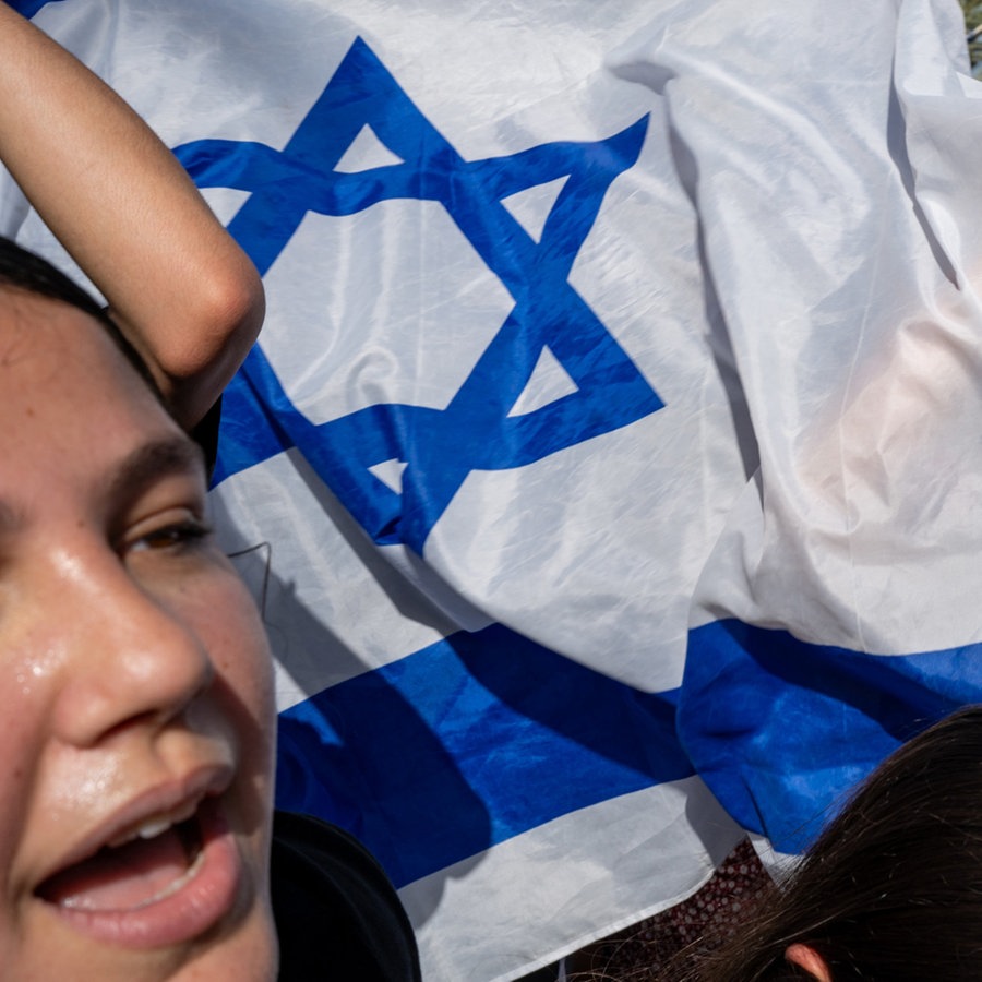 Israelis feiern mit israelischen Flaggen auf den Straßen nach der sicheren Rückkehr von vier israelischen Geiseln. © Sharon Eilon/SOPA Images via ZUMA Press Wire/dpa Foto: Sharon Eilon