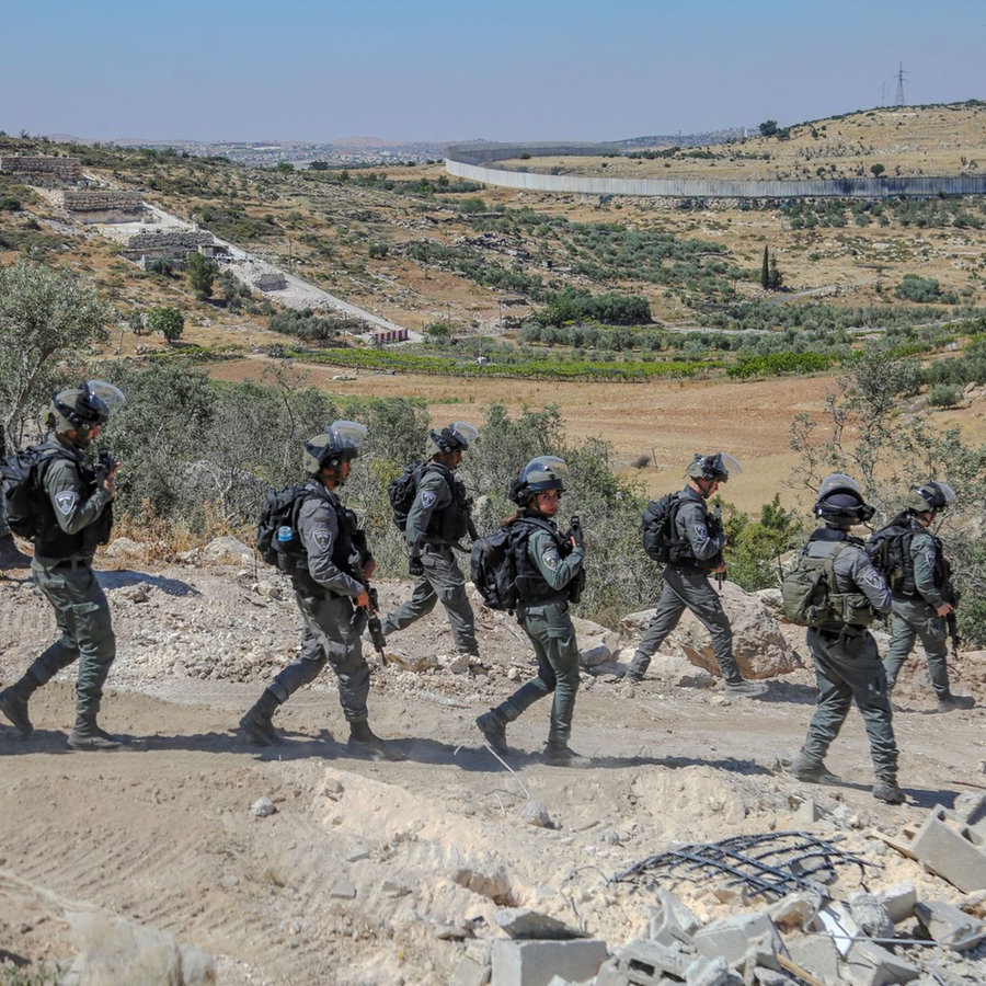 Israelische Soldaten gehen durch ein zerstörtes Gebiet. © picture alliance / Middle East Images | Mosab Shawer Foto: Mosab Shawer