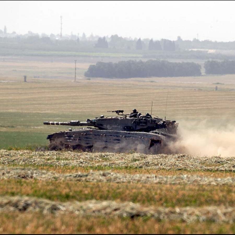 Ein israelischer Armeepanzer wirbelt Staub auf, als er im Süden Israels  nahe der  Grenze zum südlichen Gazastreifen durch das Gelände fährt. © icture alliance / newscom | Jim Hollander Foto: Jim Hollander