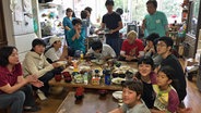 Mehrere Jugendliche sitzen in Japan in einer Küche um einen Tisch herum und essen. © NDR Foto: Kathrin Erdmann