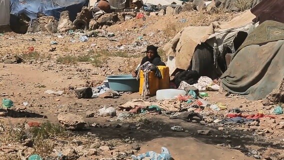 Eine hockende Frau im verwahrlosten Flüchtlingslager. © ARD 