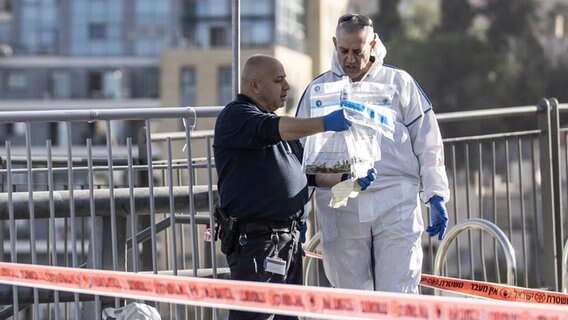 Ermittler der Polizei untersuchen Gegenstände am Tatort nach einem Anschlag in Israel. © picture alliance / Anadolu | Mostafa Alkharouf 