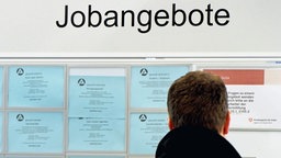 Ein Mann betrachtet die Jobangebote in der Bundesagentur für Arbeit. © dpa - Bildfunk Foto: Martin Schutt