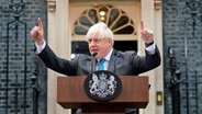 Der scheidende britische Premierminister Boris Johnson spricht vor der Downing Street, bevor er nach Balmoral in Schottland fährt, um der damaligen britischen Königin Elisabeth II. seinen Rücktritt bekannt zu geben. (Foto vom 6.9.2022) © Stefan Rousseau/PA/dpa 
