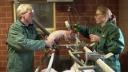 Lena Westerhoff und ihr Vater Heinz-Georg Feldhaus beim Impfen der einige Tage alten Ferkel im Schweinestall. © NDR Foto: Daniel Satra