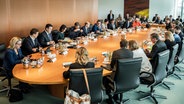 Die Mitglieder des Bundeskabinetts sitzen in einem Sitzungssaal im Bundeskanzleramt in Berlin zusammen. © dpa bildfunk Foto: Michael Kappeler