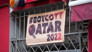 Ein Banner mit der Aufschrift "#Boycott Qatar 2022" hängt über dem Eingang einer Kneipe. © picture alliance/dpa Foto: Thomas Banneyer