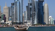 Eine traditionelle Dhau liegt vor der Skyline von Doha. © Federico Gambarini/dpa 