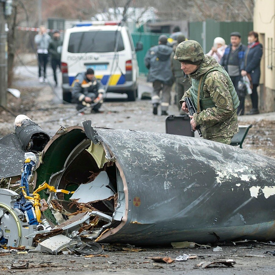 Ein Soldat der ukrainischen Armee inspiziert in Kiew Teile eines abgestürzten Flugzeugs. © dpa-Bildfunk/AP Foto: Vadim Zamirovsky