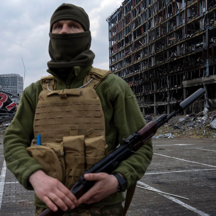 Ein Soldat steht in der Nähe eines zerstörten Einkaufszentrums in Kiew © Rodrigo Abd/AP/dpa 