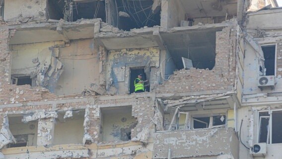 Ein Mann steht in einem Gebäude in Kiew, das bei dem dritten russischen Luftangriff auf die ukrainische Hauptstadt innerhalb der letzten 24 Stunden stark beschädigt wurden. © Aleksandr Gusev/SOPA Images via ZUMA Press Wire/dpa 
