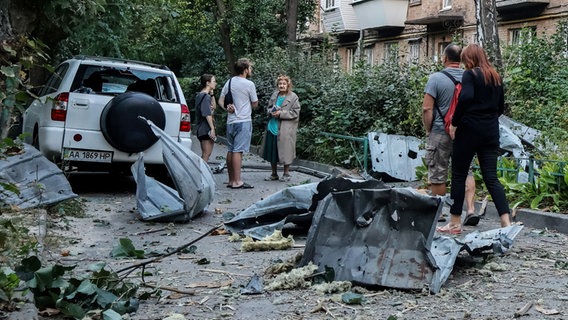 Ukraine, Kiew: Anwohner stehen in der Nähe ihres Wohnhauses, das bei einem Raketenangriff auf die Ukraine beschädigt wurde. © Aleksandr Gusev/SOPA Images via ZUMA Press Wire/dpa 