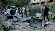 Ukraine, Kiew: Anwohner stehen in der Nähe ihres Wohnhauses, das bei einem Raketenangriff auf die Ukraine beschädigt wurde. © Aleksandr Gusev/SOPA Images via ZUMA Press Wire/dpa 