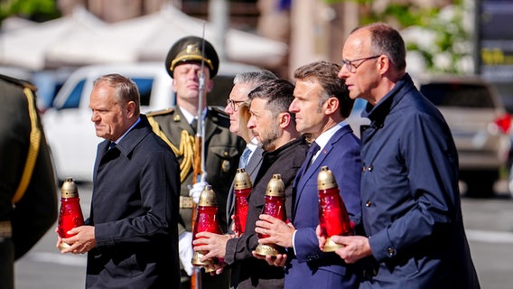 Donald Tusk, Regierungschef von Polen, Keir Starmer, Premierminister von Großbritannien, Wolodymyr Selenskyj, Präsident der Ukraine, Frankreichs Präsident Emmanuel Macron und Bundeskanzler Friedrich Merz gedenken mit Kerzen in der Hand in Kiew auf dem Maidan den Opfern des Krieges. © dpa Foto: Kai Nietfeld
